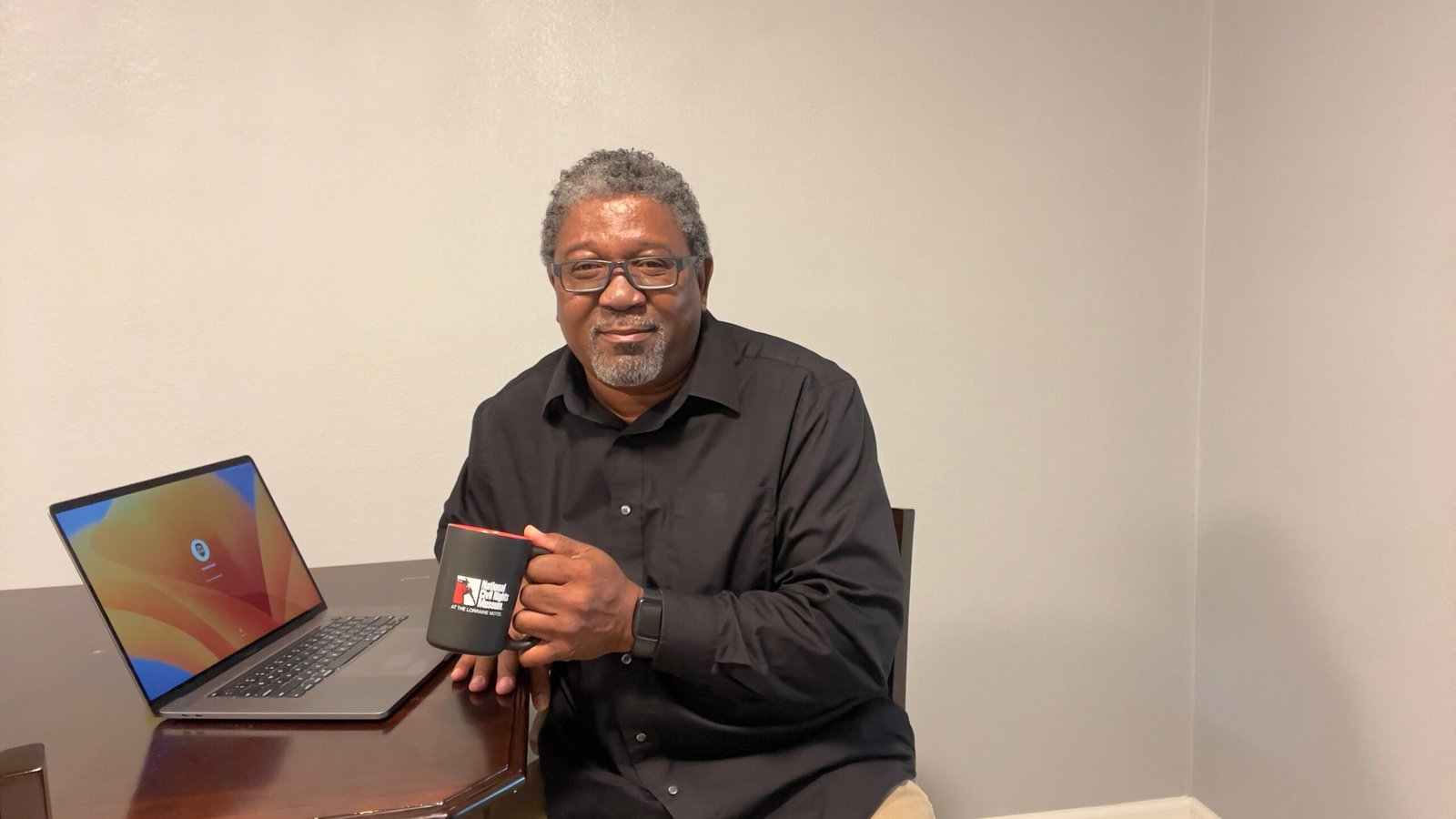 IMG_9047 Rafael Powell sitting at table in front of laptop with a cup of coffee